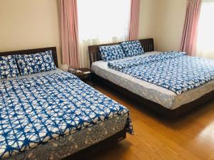 two beds sitting in a room with at Kaen in Tachikawa