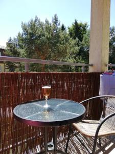 una copa de vino sentada en una mesa en un patio en Apartament Sosnowy en Ustka