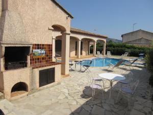 eine Terrasse mit einem Tisch und Stühlen neben einem Pool in der Unterkunft VILLA SPACIEUSE, CLIMATISATION, PISCINE, JARDIN PAYSAGE, PROCHE MER in Saint-Cyr-sur-Mer