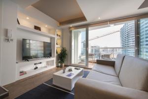 a living room with a couch and a tv at Stylish Seaview Apartment In a Prime Location in Sliema