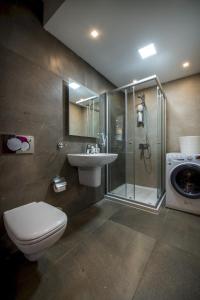 a bathroom with a shower toilet and a sink at Stylish Seaview Apartment In a Prime Location in Sliema