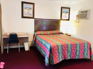 Cette chambre comprend un lit avec une couverture colorée. dans l'établissement Griffith Park Motel, in Los Angeles Hollywood Area, à Glendale