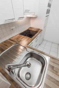 a kitchen with a sink and a stove at Residenz Alpina im Kurhaus in Lenzerheide +31 photos