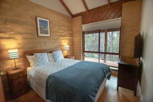 1 dormitorio con cama y ventana grande en Denmark Forest Retreat, en Denmark
