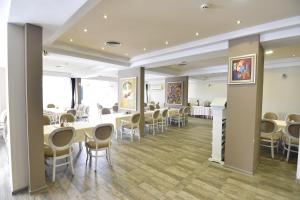 une salle à manger avec des tables et des chaises blanches dans l'établissement Panorama Hotel, à Sandanski