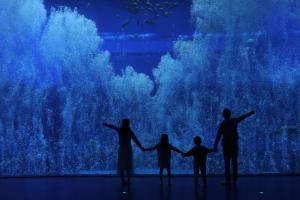 a group of people standing in front of a large aquarium at Pullman Nanchang Sunac in Nanchang