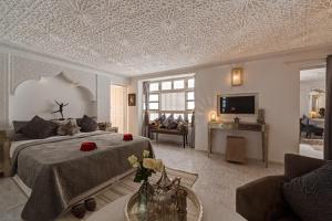 a bedroom with a bed and a living room at Riad Star by Marrakech Riad in Marrakesh