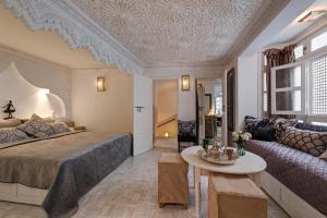a bedroom with a bed and a couch and a table at Riad Star by Marrakech Riad in Marrakech