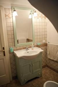 een badkamer met een wastafel en een spiegel bij Appartamenti Fusaro in Specchia