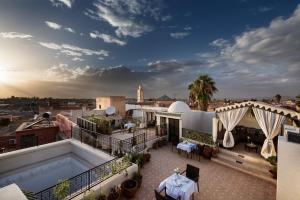 a rooftop patio with a pool on a building at Riad Star by Marrakech Riad in Marrakesh