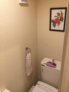 a bathroom with a toilet and a picture of flowers on the wall at 駅近-JR小岩駅まで徒歩3分 Leo小岩203 in Tokyo
