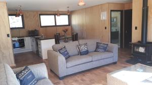 a living room with a couch and a kitchen at Marlborough Sounds Accommodation in Havelock
