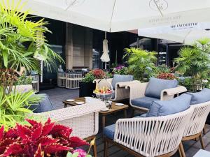 a patio with chairs and tables and plants at Plaza Hotel Yuyao in Yuyao