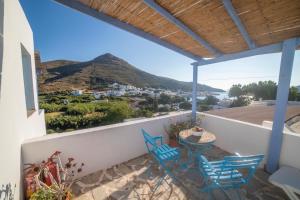 a balcony with blue chairs and a table with a view at Amorgaia 2 in Katapola