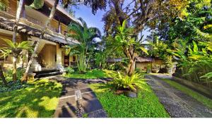 un patio de una casa con árboles y plantas en Bali Agung Village - CHSE Certified, en Seminyak