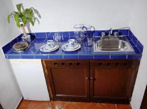 a kitchen with a sink and a blue counter top at Hotel Los Girasoles in Cancún