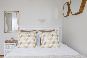 Banana palm luxury cottage في ديربان: غرفة نوم بسرير ابيض مع وسادتين +9 صور