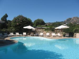 a large swimming pool with chairs and umbrellas at Hotel Valdiola in Porto Cervo