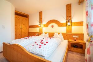 a bedroom with a large bed with red roses on it at Haus am Waldrand in Leutasch