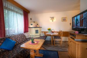 uma sala de estar com um sofá e uma mesa em Haus am Waldrand em Leutasch