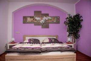 Un dormitorio con una cama con una pared morada. en Apartments Stirl, en Dresden