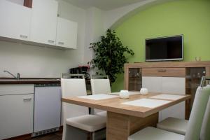 Una cocina con una mesa de madera con sillas y un televisor. en Apartments Stirl, en Dresden 19 fotos más
