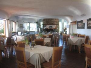 comedor con mesas y sillas y chimenea de piedra en Hotel Valdiola, en Porto Cervo