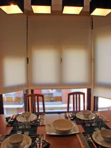 una mesa con sillas, platos y vasos. en Apartamentos Legazpi, en Albacete