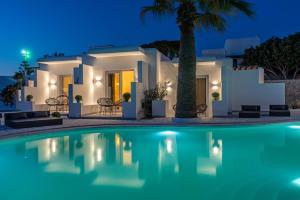 una villa con piscina di notte di Omnia Mykonos Boutique Hotel & Suites a Ornos