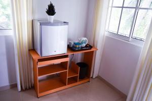 a small table with a tv on a table next to a window at City Breeze Residence in Kandy