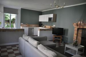 a living room with a couch and a kitchen at Maison d'hôtes Paris Riverside in Saint-Maur-des-Fossés