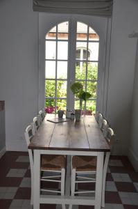 a dining room table with chairs and a large window at Maison d'hôtes Paris Riverside in Saint-Maur-des-Fossés