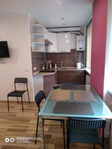 a kitchen with a table and chairs in a room at Sparta Apartments Bastrakovi in Narva