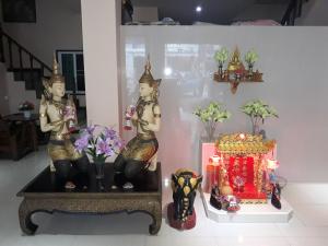 a room with two statues and a table with flowers at SorotHouse in Jomtien Beach