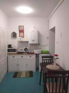 a kitchen with white cabinets and a table and a sink at Sara House in Bistriţa