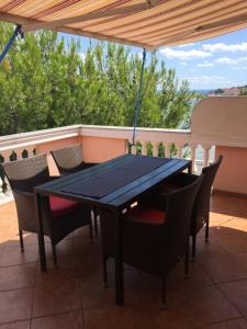 a black table and chairs on a patio at Apartmani MM in Tkon