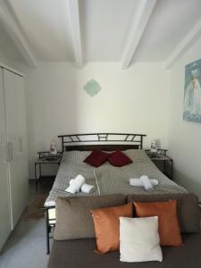 Schlafzimmer mit einem Bett mit roten und weißen Kissen in der Unterkunft App Neno in Murine