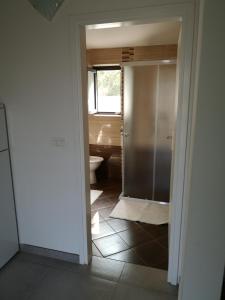 ein Badezimmer mit einem WC und einer Glastür in der Unterkunft App Neno in Murine