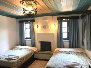 two beds in a bedroom with a fireplace and a chandelier at Mousafir Ontas in Kapesovo