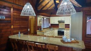a kitchen with a table and chairs and two lights at House 30, Sodwana Bay Lodge in Sodwana Bay
