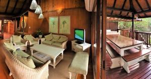 a living room with a television on a deck at House 30, Sodwana Bay Lodge in Sodwana Bay