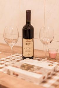 a bottle of wine and two wine glasses on a table at Apartman Preko Morace 2018 in Podgorica