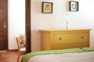 ein Schlafzimmer mit einem Bett und einer Kommode mit zwei Bildern in der Unterkunft Posada del Candil in Serón