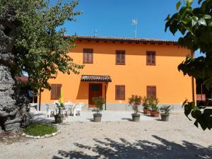 an orange building with tables and chairs in a courtyard at AL MORAR in Farra dʼlsonzo