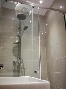 a bathroom with a shower with a tub and a sink at BrasovApart Piata Sfatului 1 in Braşov
