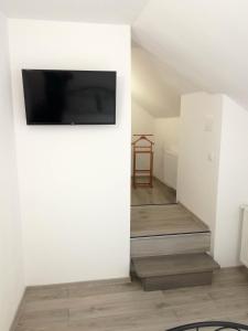 a living room with a tv on a wall at BrasovApart Piata Sfatului 1 in Braşov +12 photos