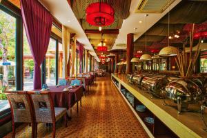 a restaurant with long tables and chairs and windows at Seava Ho Tram Beach Resort in Ho Coc