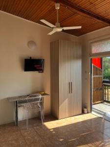 salon ze stołem i wentylatorem sufitowym w obiekcie Casa Vacanze Bungalow I Girasoli w mieście Ventimiglia