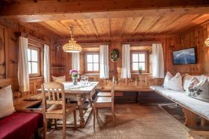 ein Esszimmer mit einem Tisch und einem Sofa in der Unterkunft Krumpenhof in Söll