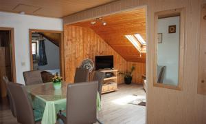 a dining room with a table and chairs and a television at Ferienwohnung Dichtl in Grafenau